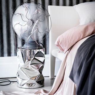 bedside fan on steel design cylindrical stand in bedroom