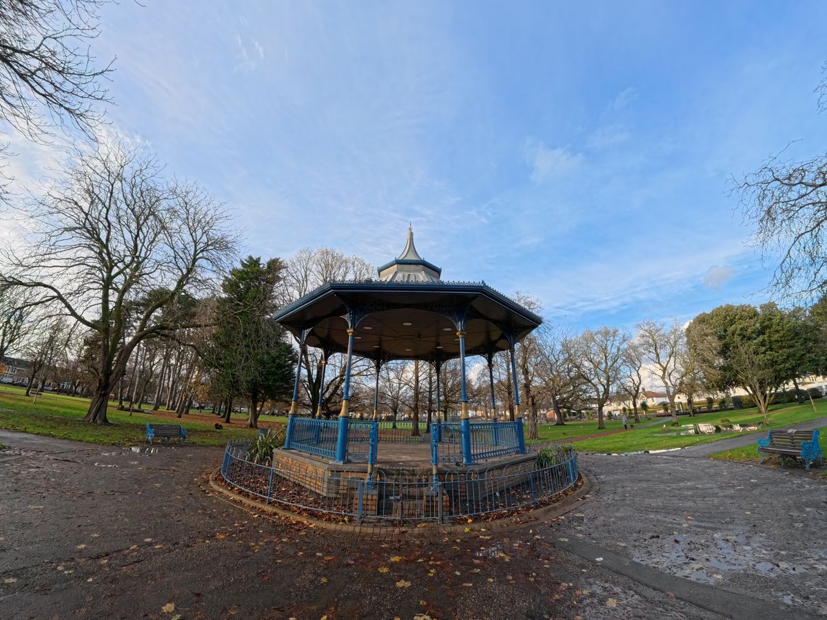 A photo of a pavilion in a park with trees and a blue sky in the background. Shot on the Insta360 Ace Pro in Mega FoV.