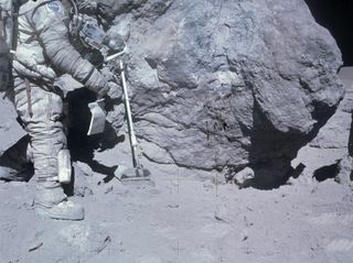 Apollo 16 astronaut Charlie Duke collects lunar samples during a moonwalk.
