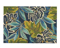 An outdoor rug with a bold multicolored tropical leaf pattern