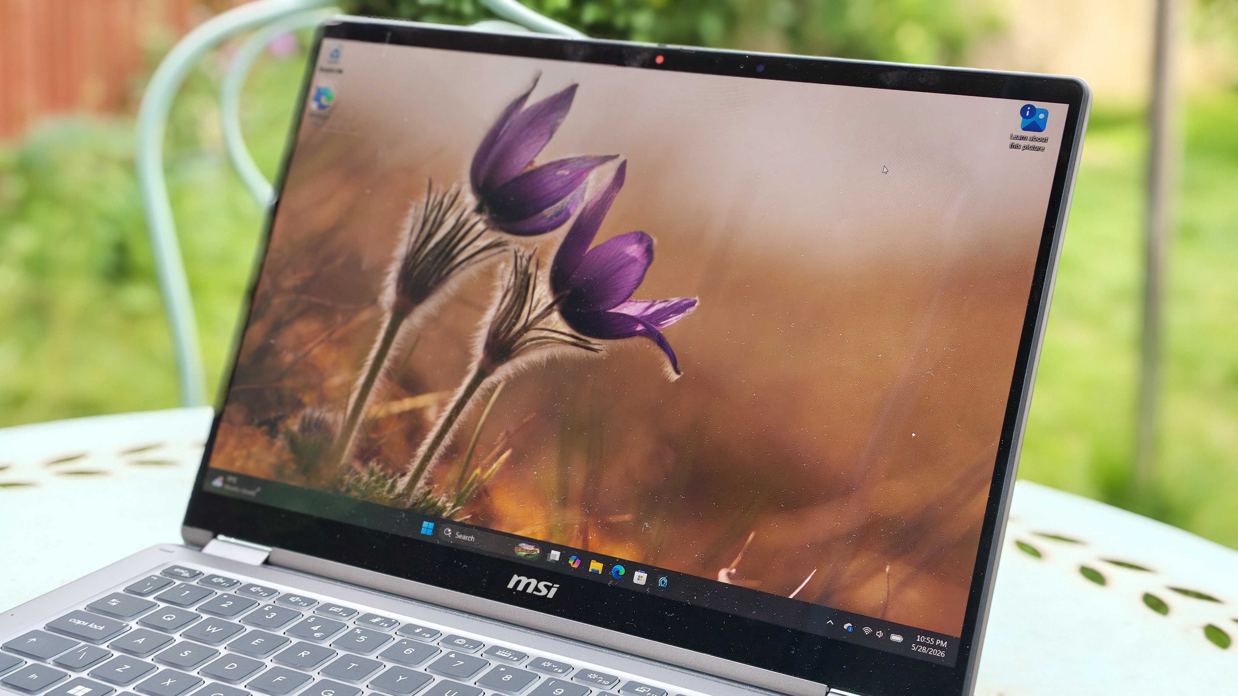 A silver MSI Prestige 14 Flip AI+ laptop on a garden table