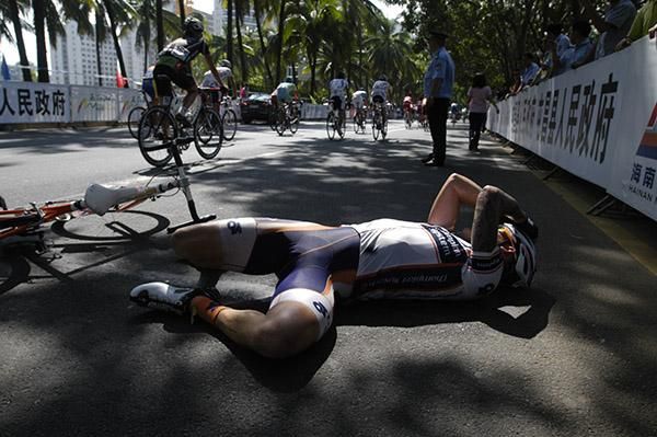 An exhausted Deon Locke (Champion Systems) lies on the ground as the peloton go by in Haikou.
