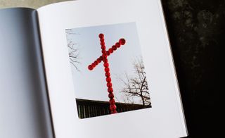 Image in a book of a cross made out of red glass balls