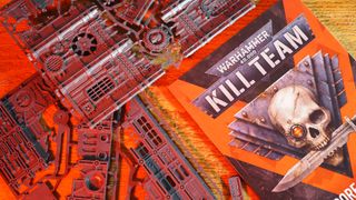 Kill Team: Hivestorm 핵심 규칙과 스프루가 나무 테이블에 놓여 있습니다.