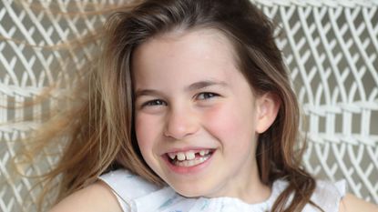 Princess Charlotte smiling widely in a hammock