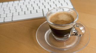 Cup of espresso by a computer keyboard