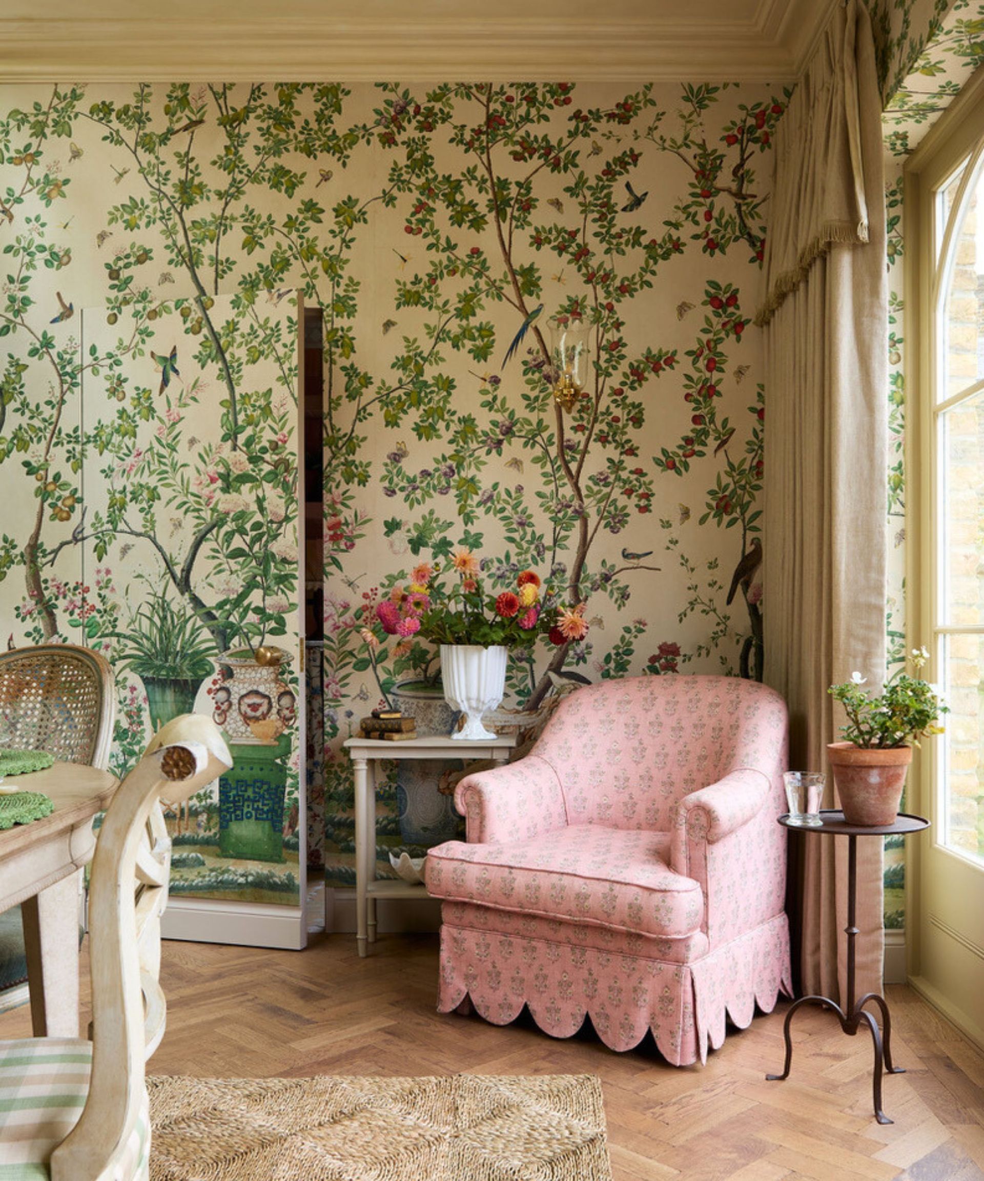dining room with Chinoiserie wallpaper and a pink skirted chair with scallop edging