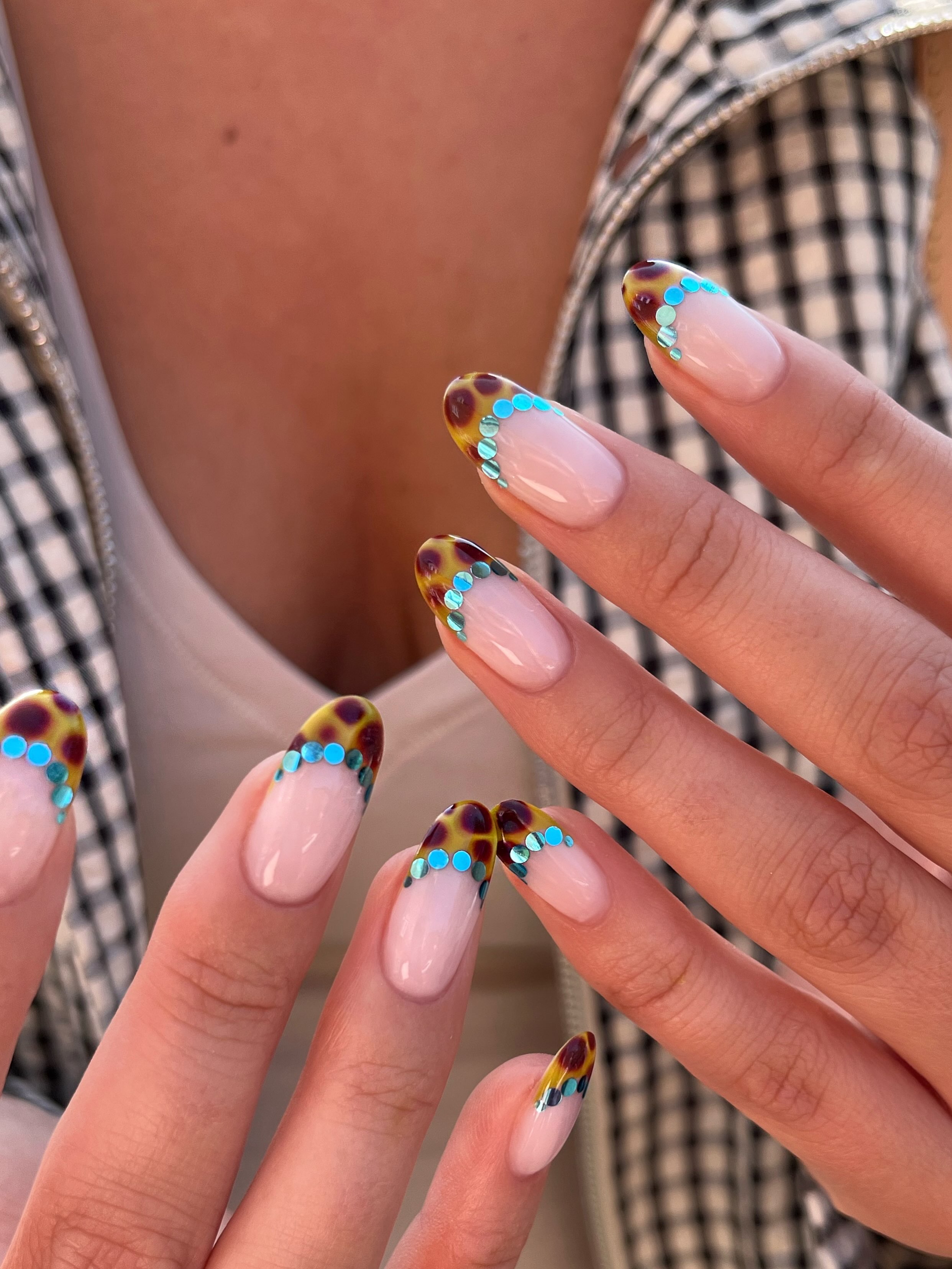 nude almond nails with tortoiseshell French tips and bright turquoise sequins