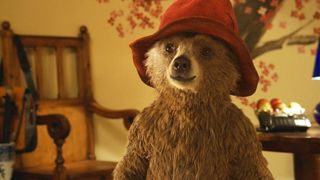 Paddington the bear in his red hat in a warmly lit room in Paddington, one of the Best family movies on Netflix