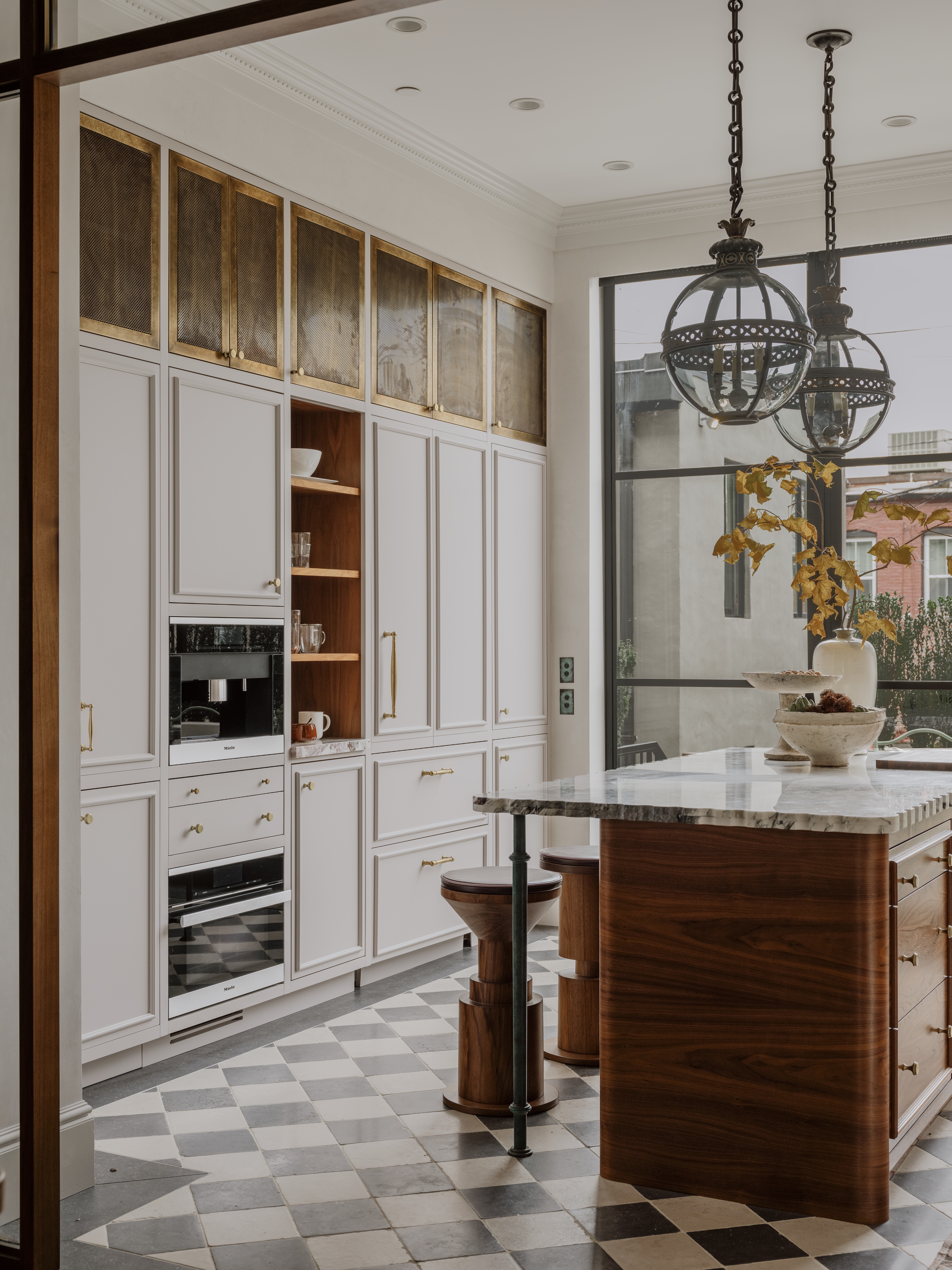A muted kitchen with a small block island, and closed storage from the floor to the ceiling