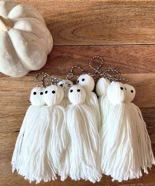 DIY decorating idea with white ghoul garland made out of wool with white pumpkin in background