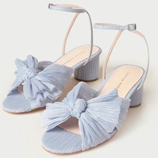 Cutout of blue bow sandals by Loeffler Randall shot on a grey background