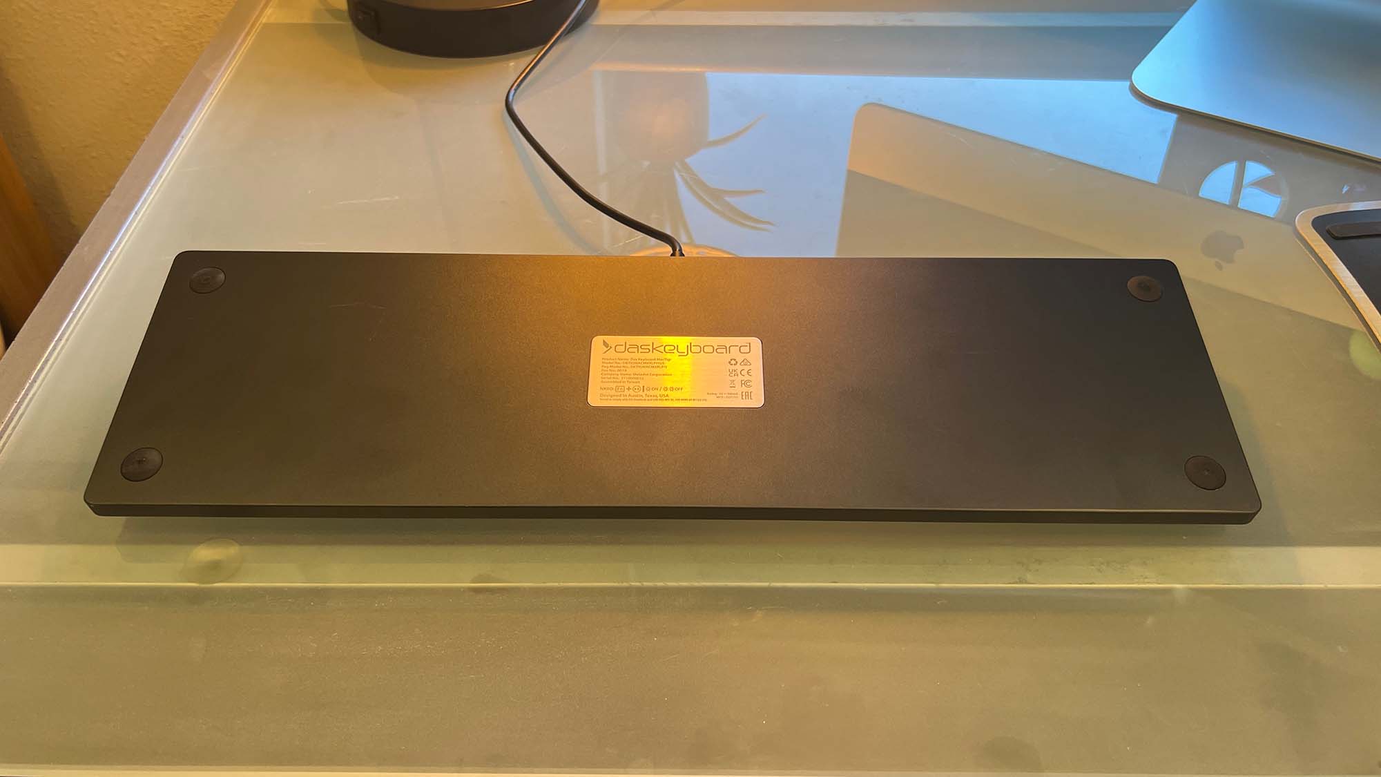 A Das Keyboard MacTigr on a glass top desk