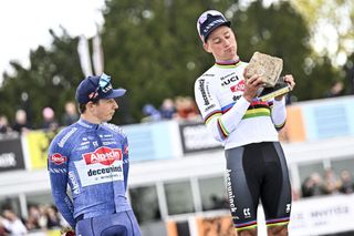 Mathieu van der Poel celebrates on the podium with his Alpecin-Deceuninck teammate Jasper Philipsen after winning the 2024 Paris-Roubaix