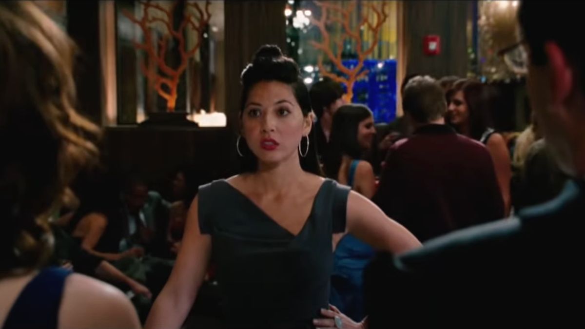 Olivia Munn in a green dress speaking with Steve Carrell and Tina Fey at a podium in Date Night 