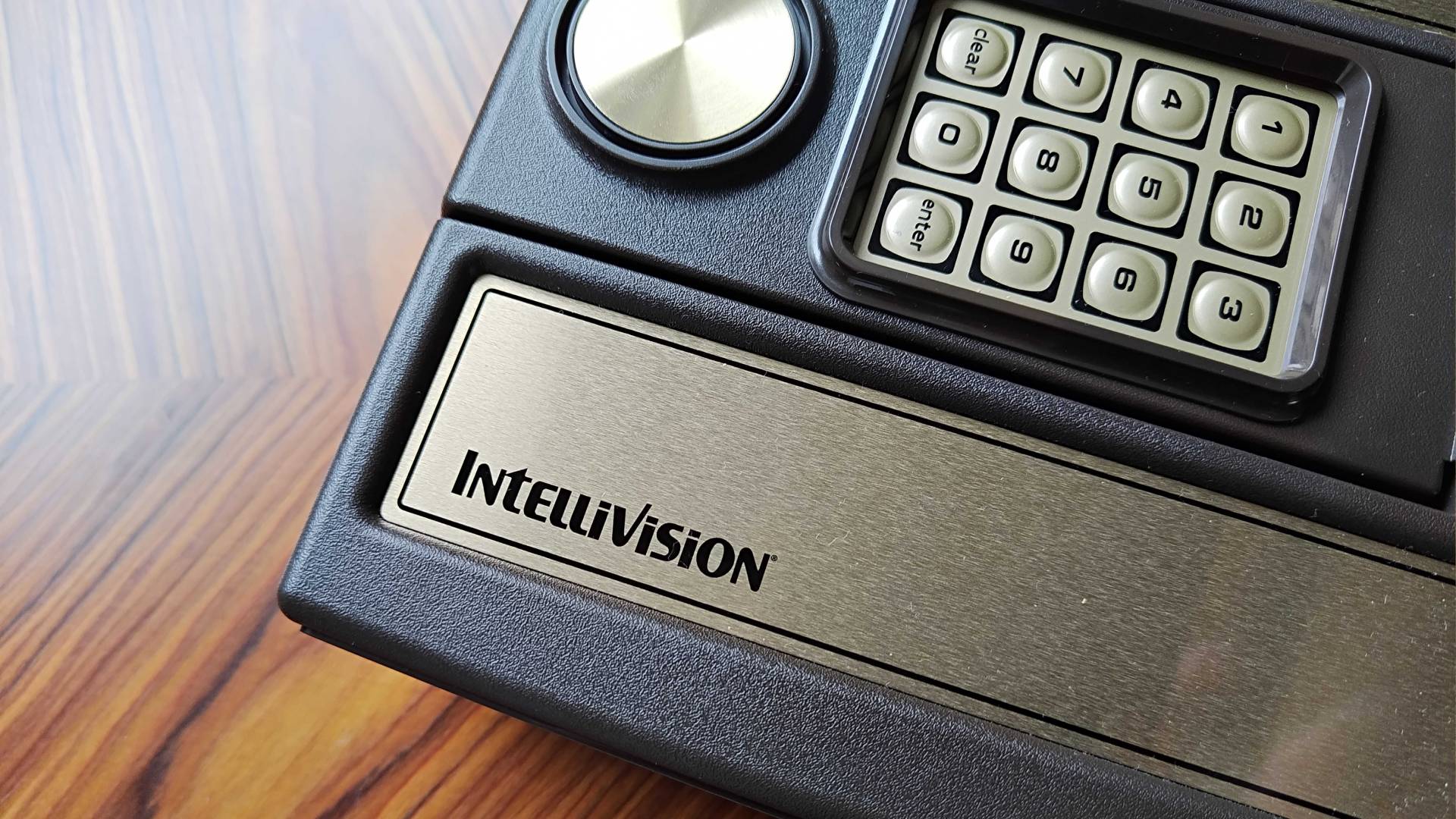 Close up of Intellivision logo on Sprint console sitting on woodgrain desk.