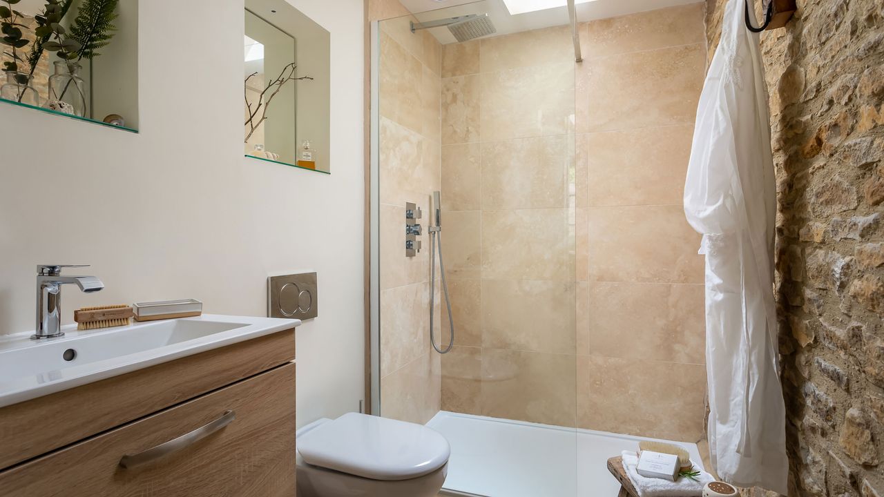 shower room with exposed stone walls