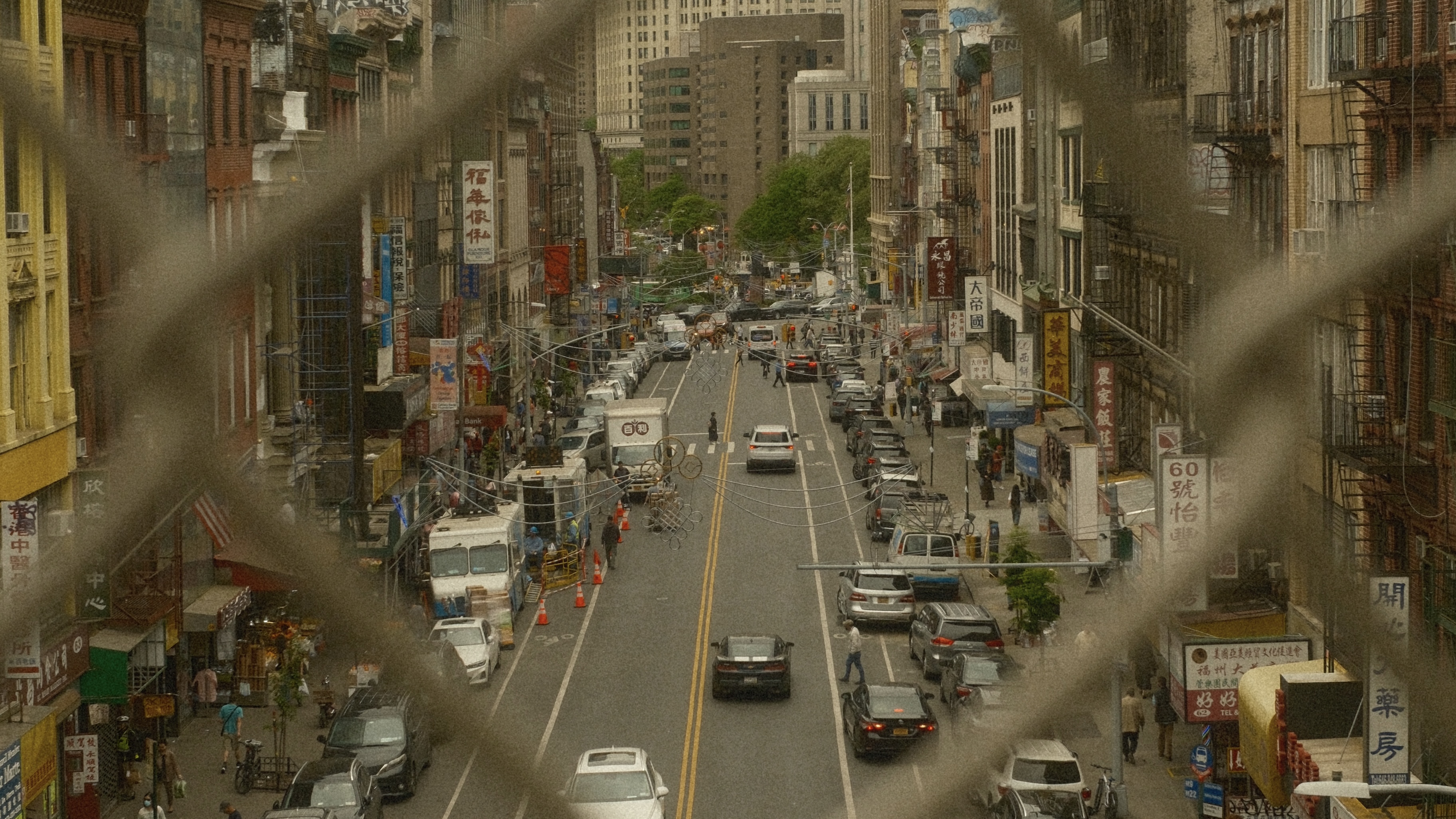 Une rue animée de New York vue à travers une clôture métallique
