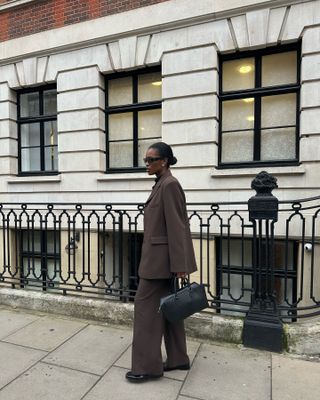 Fashion influencer @nlmarilyn in Europe wearing a chic outfit for 2025 styled with a blazer.