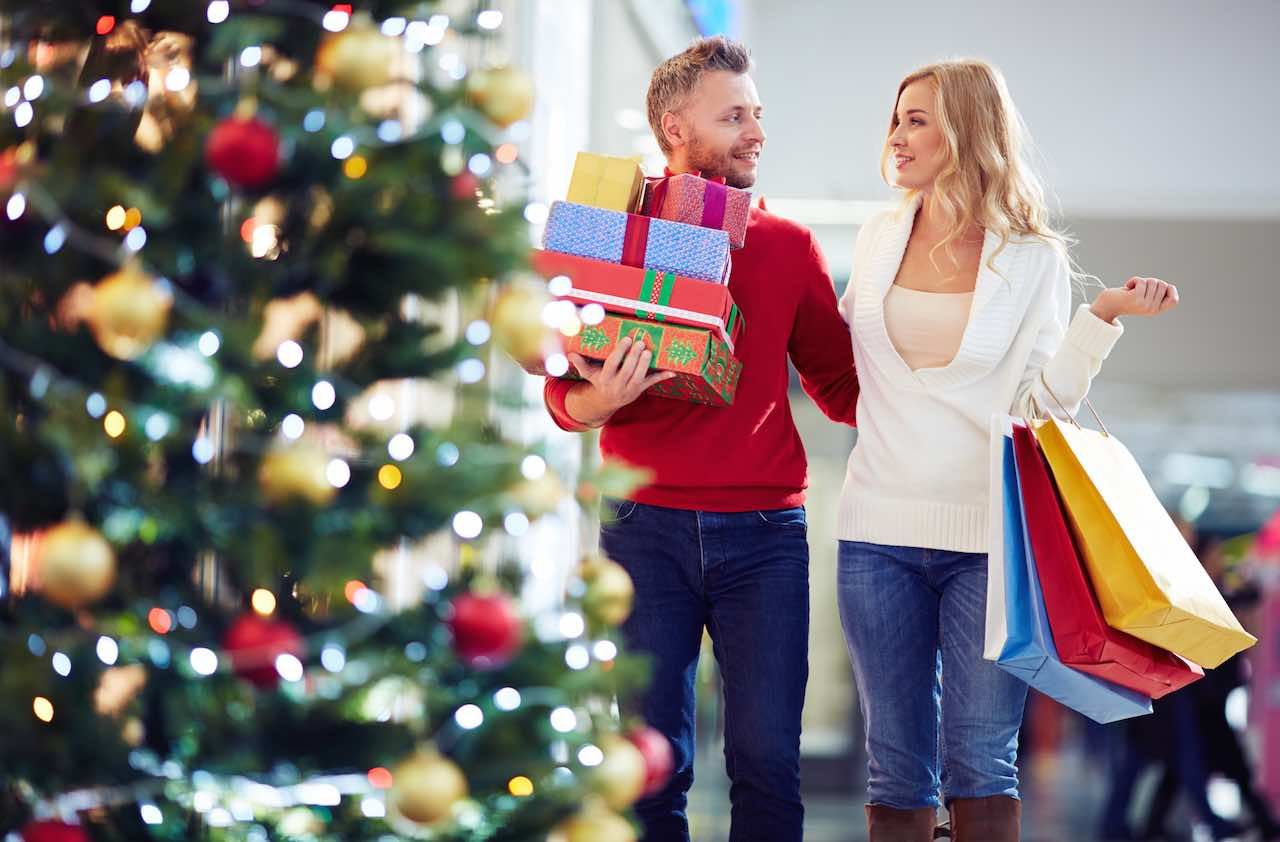 Affectionate couple carrying Christmas presents while shopping in the mall