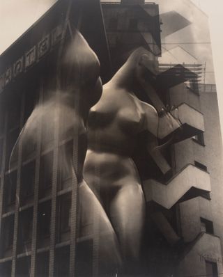 A photo of a building with the Hotel sign on it and the image of 2 faceless nude women. Photographed in grey shades