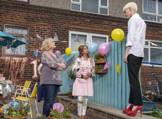 Jamie (Max Harwood) shows off his new red high heels in the garden for his mother Margaret (Sarah Lancashire) and her friend Ray (Shobna Gulati)