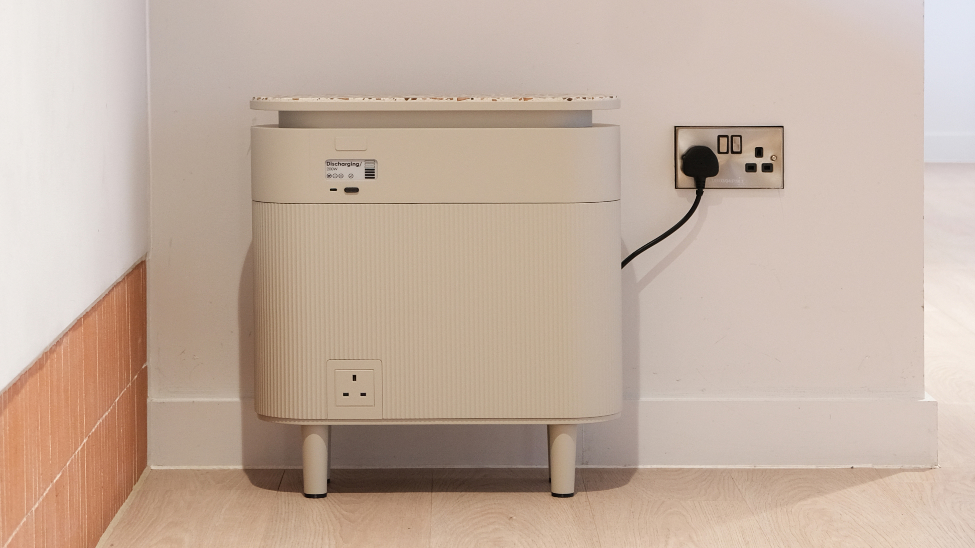 A Windfall Energy plug-in battery plugged into a home wall socket