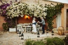 Wide shot of senior couple dancing in garden of tropical villa at sunset while on vacation in Morocco