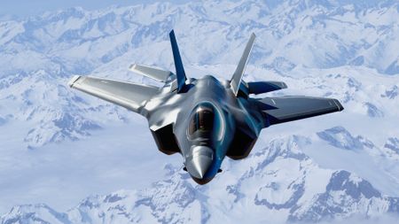 An F-35 Lightning II flying over snow-capped mountains