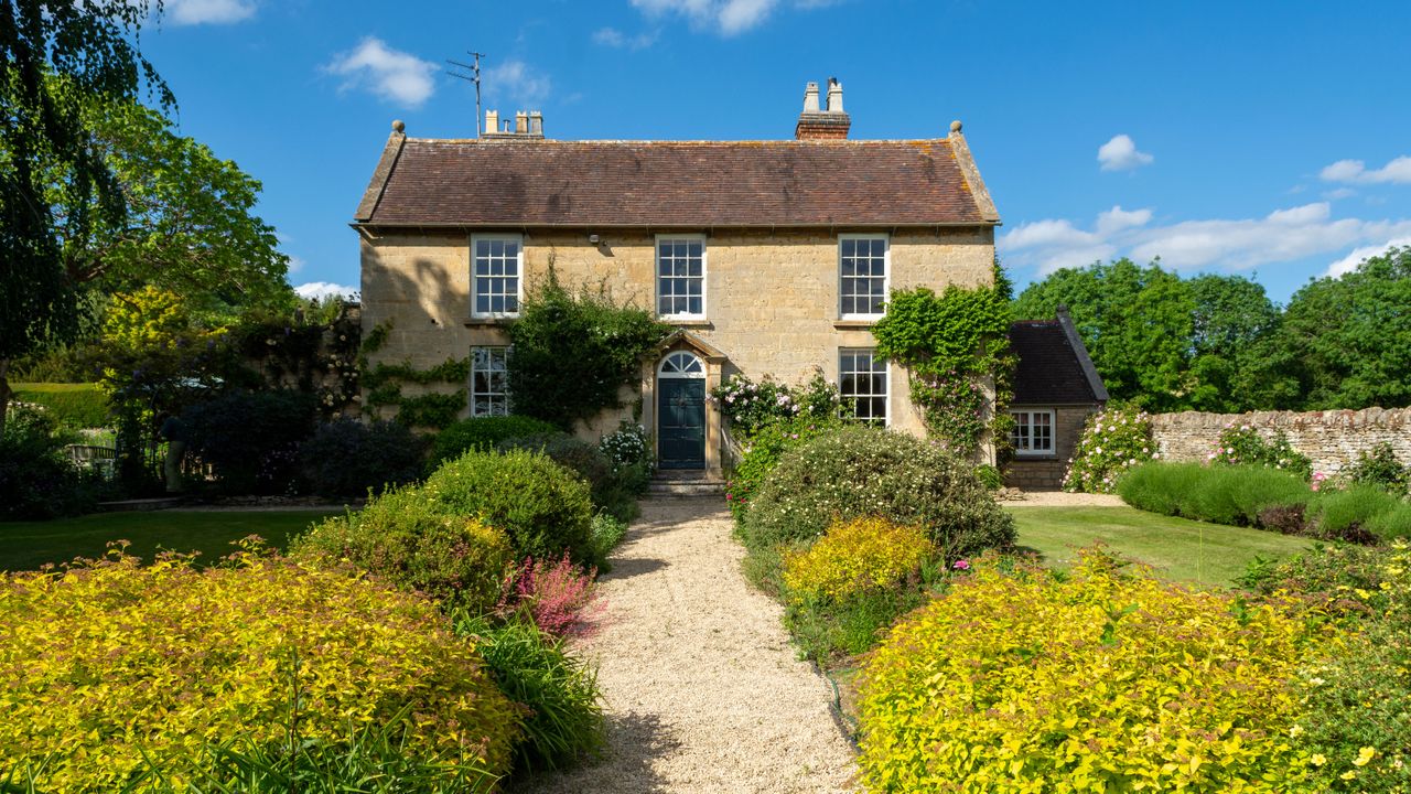 english country garden to a georgian home with gravel pathway leading to door