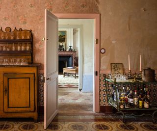 A french country house with an antique drinks trolley filled with bottles, glassware, and brass decor