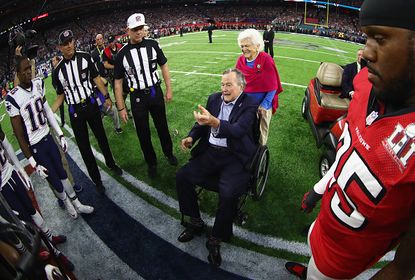 Former President George H.W. Bush assists with the coin toss at the beginning of Super Bowl LI.