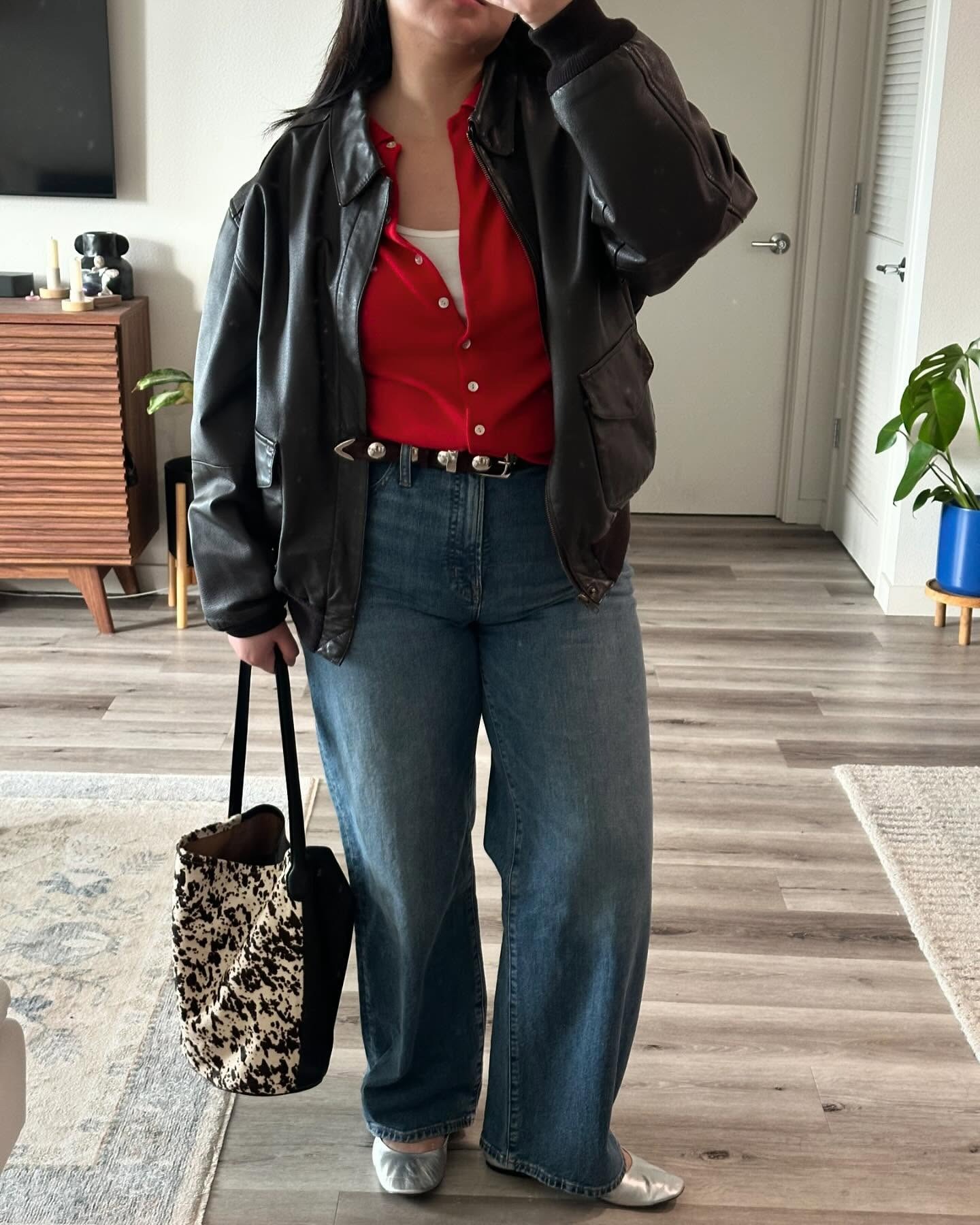 Influencer @marina_torres wears a red cardigan and jeans and a leather jacket.