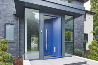 blue front door with covered porch lighting