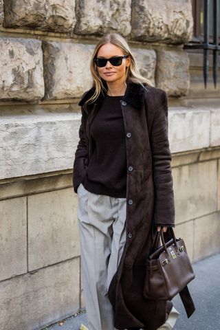 Woman in dark brown coat and sweater