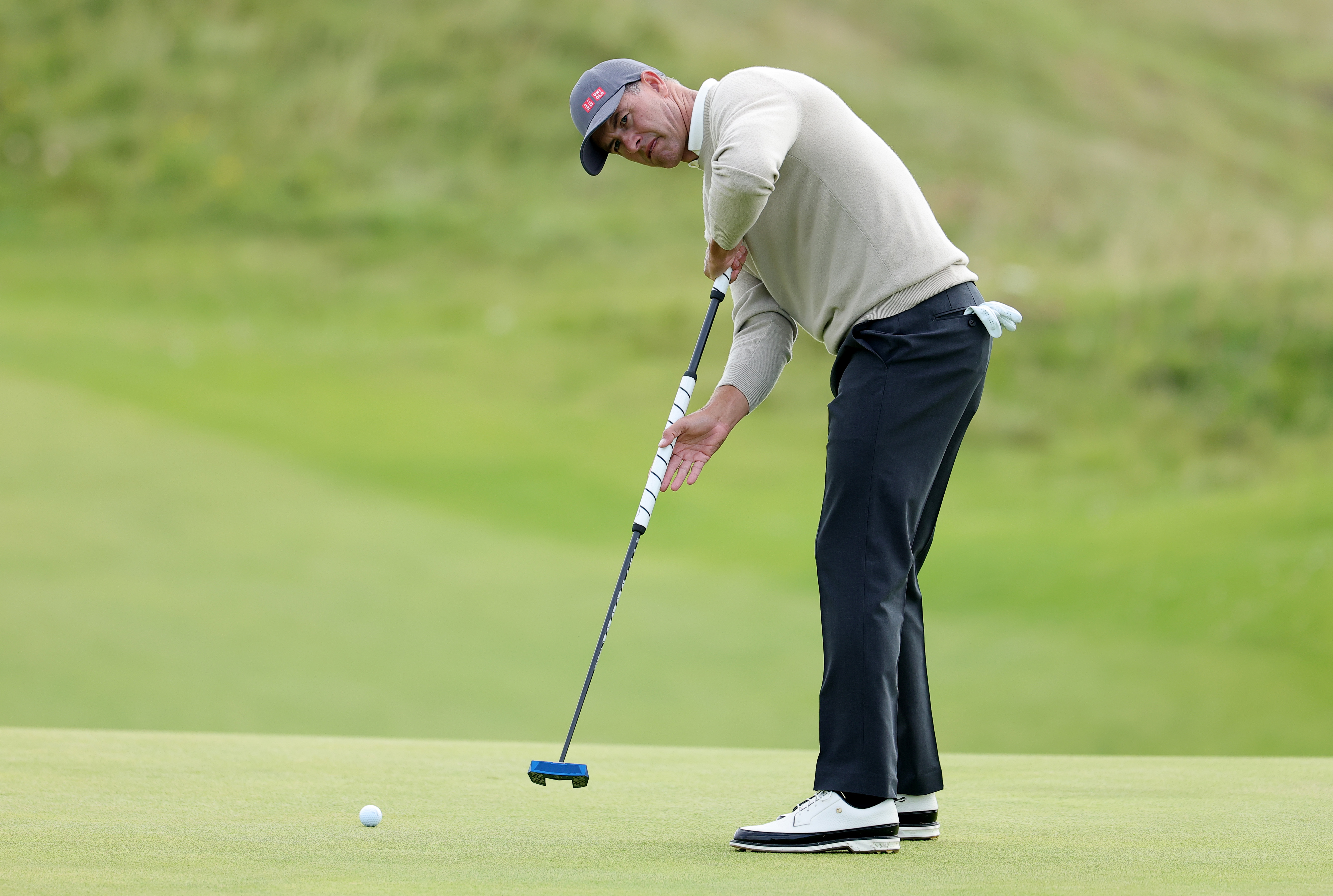 Adam Scott hits a putt on the green