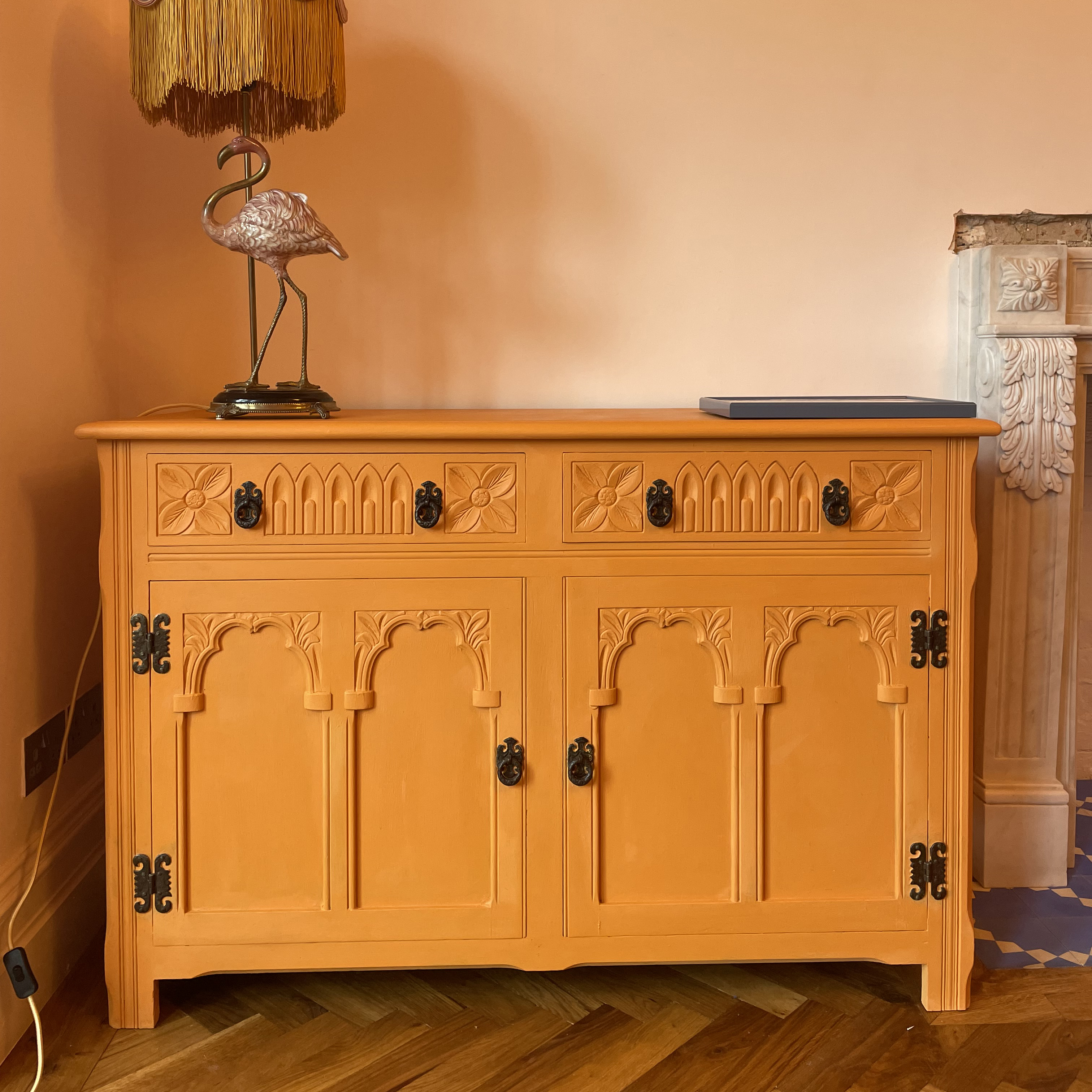 orange dresser with flamingo lamp on the top