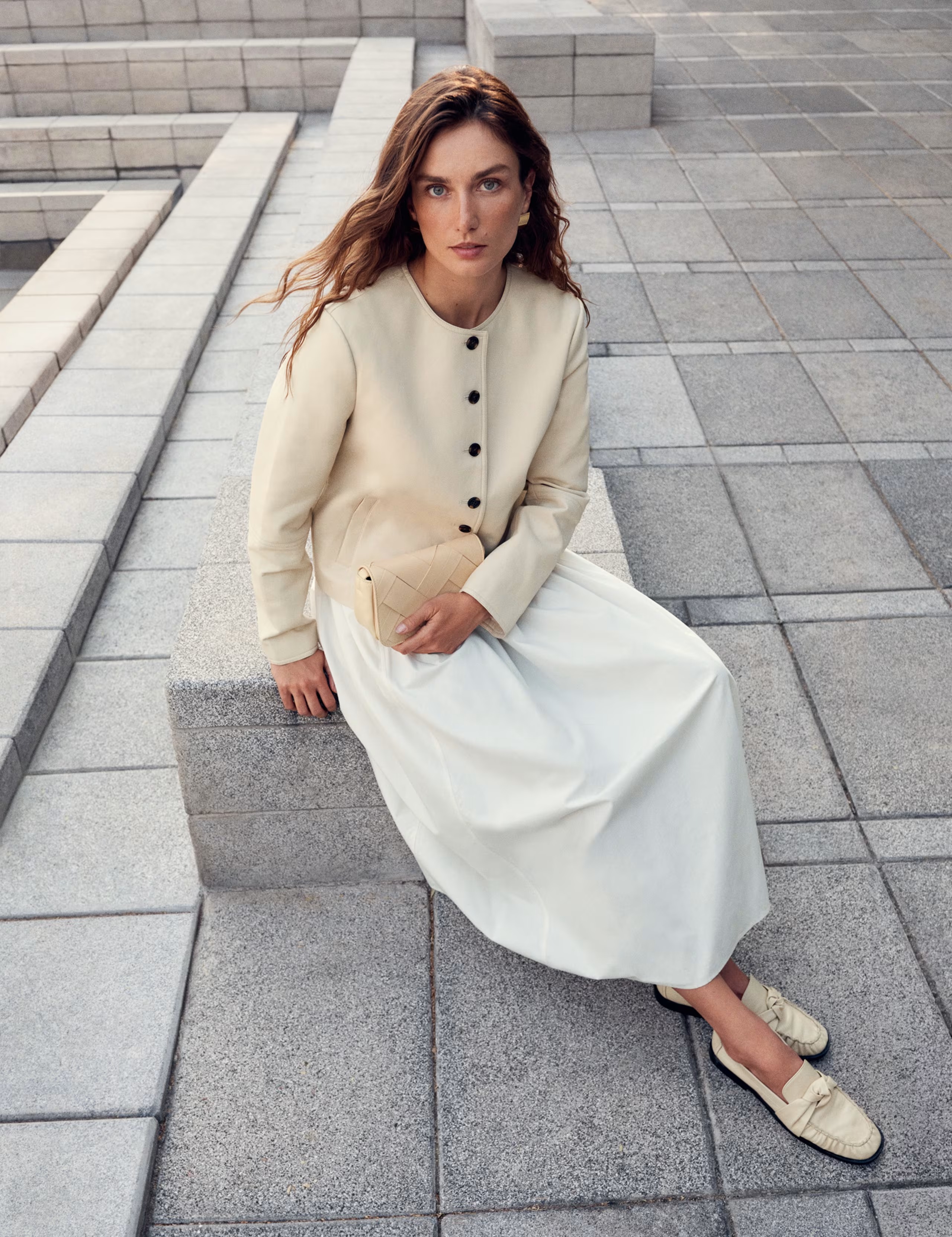 Marks and Spencer campaign image showing a model wearing a cream cardigan, white skirt and cream loafers