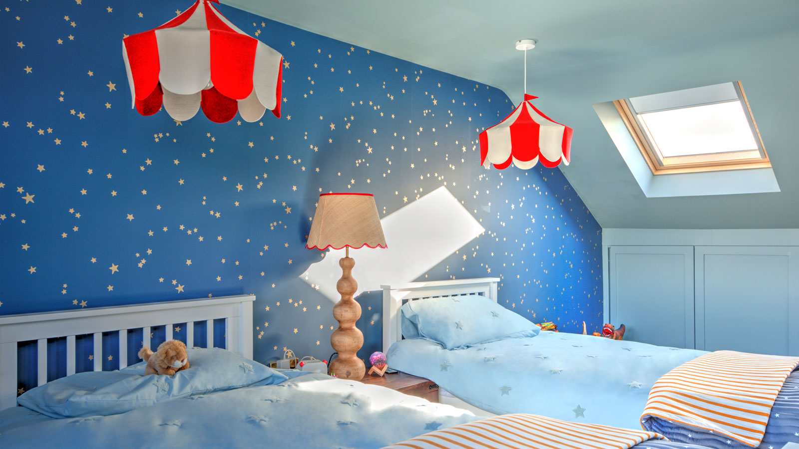 loft conversion children's bedroom with blue star wallpaper and red and white lights