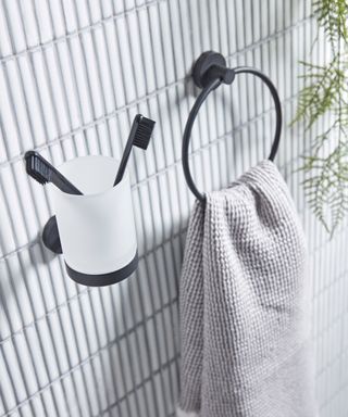 A black and white toothbrush holder and towel ring