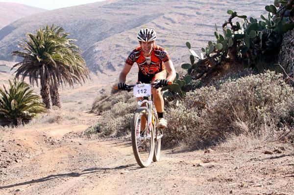 A racer passes palm trees