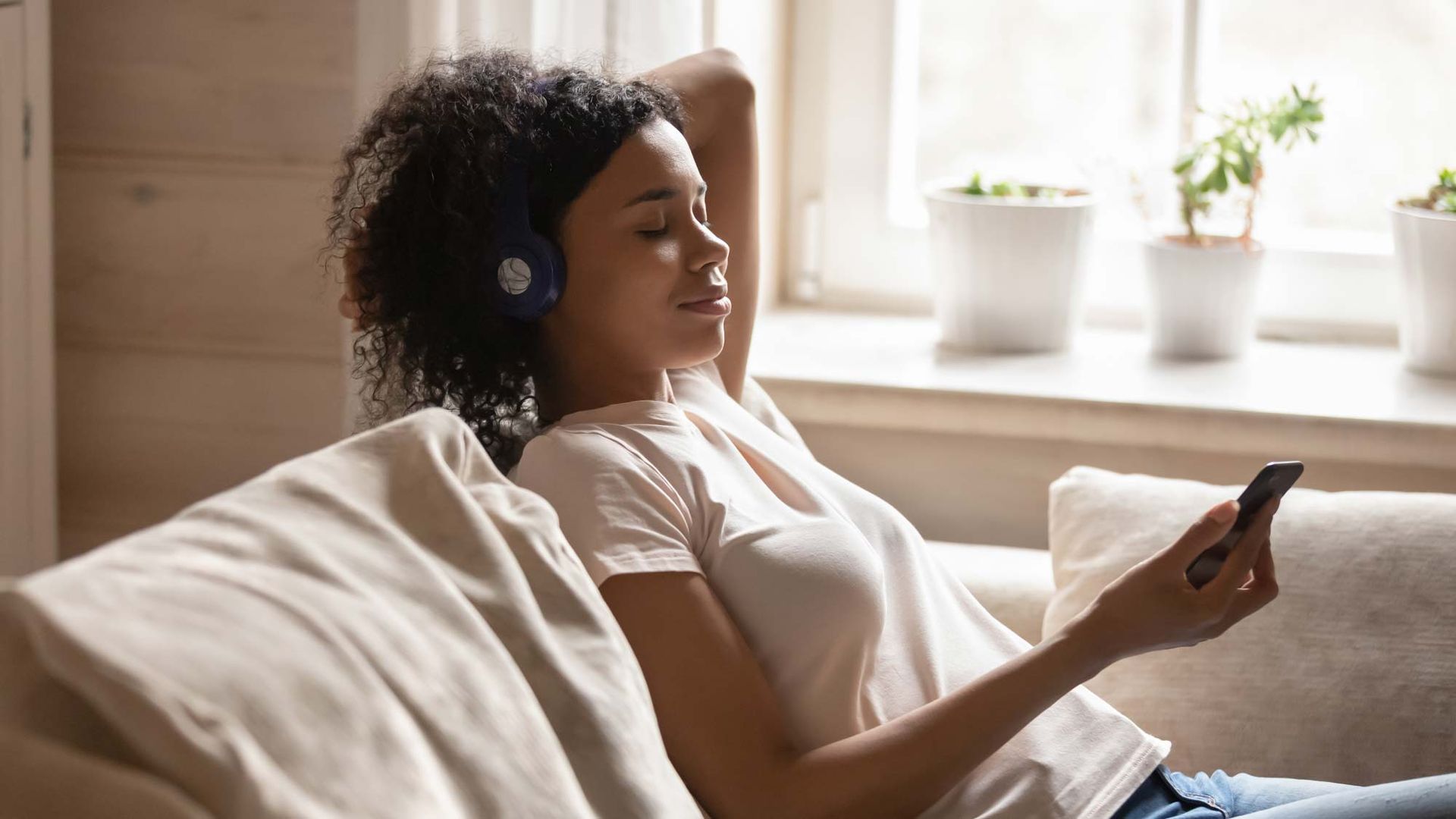 Надела слушать. Человек в наушниках лежа на кровати медитация. Woman Listening to Music at Home. Слушает телефон. She enjoys Listening to Music.