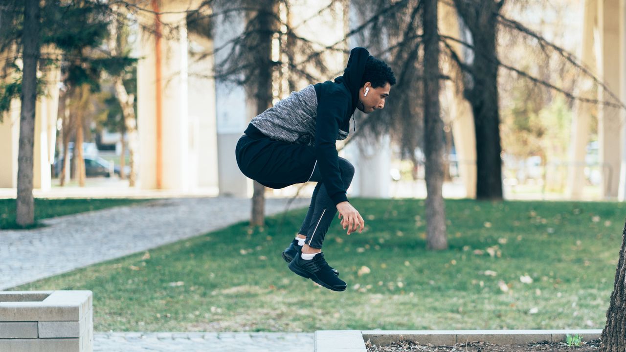 Man doing a squat jump to develop butt, legs and lose weight