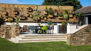 outdoor kitchen on raised patio with living wall