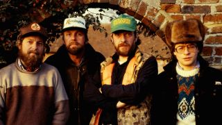 Jethro Tull posing for a photograph in front of a brick wall in 1984