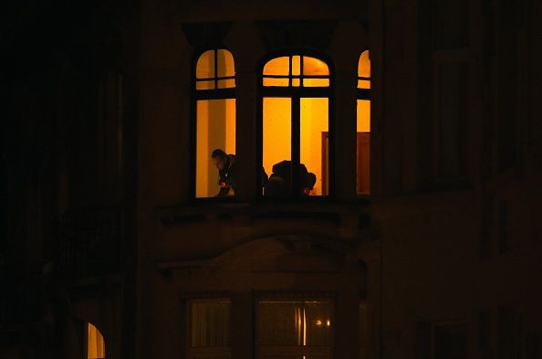 Police conduct a raid inside an apartment in Brussels.