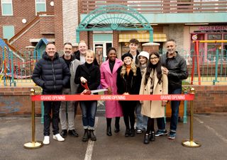 Coronation Street cast pose in front of Weatherfield Precinct and Grand Opening red ribbon