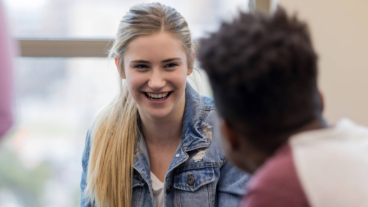 A young woman and man talk.