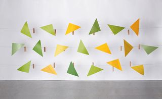 Installation comprises triangular curved tulipwood parts painted in bright pops of yellow and green