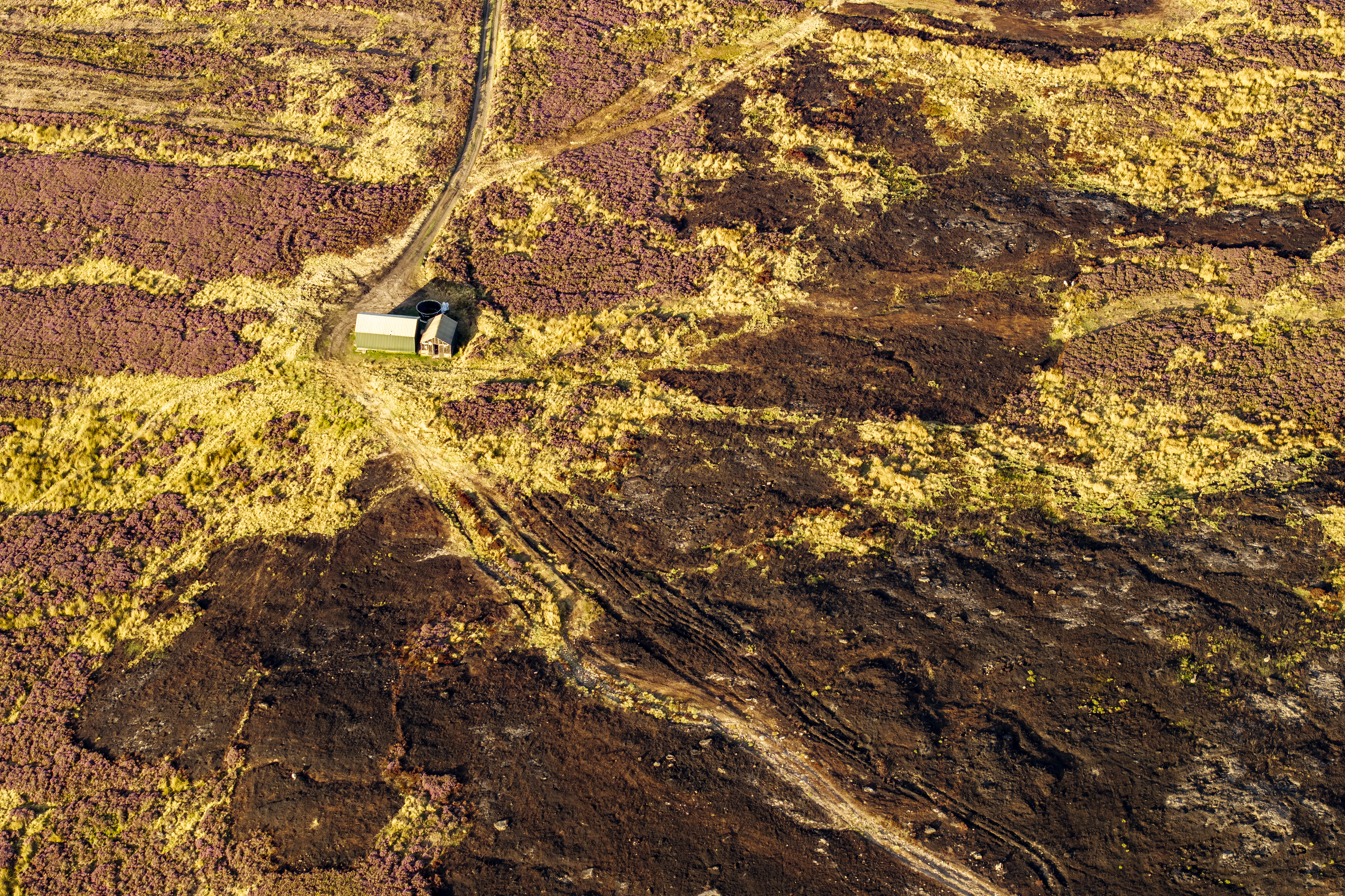 GLOSSOP, ENGLAND - AUGUST 24: An aerial view of burnt ground at Tintwistle Moor on August 24, 2026 in Glossop, United Kingdom. The Tintwistle Moor wildfire, one of England&amp;rsquo;s largest wildfires in recent years, began on June 24 and burned an estimated 606 hectares (1,497 acres) of moorland and woodland. The fire, which was declared a major incident on July 13, burned for more than six weeks before being brought under control. With 71% of England in drought, high-risk areas such as moorland across the Peak District are in dire need of rain to prevent further wildfires. (Photo by Brook Mitchell/Getty Images)